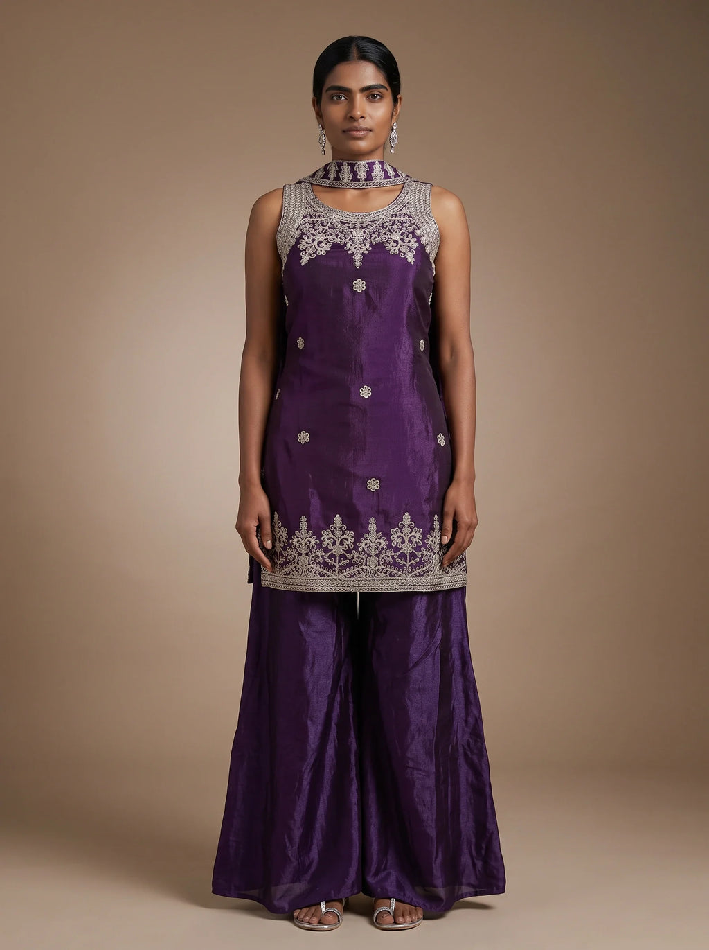 Model wearing violet tissue silk zari embroidered sharara set with matching dupatta