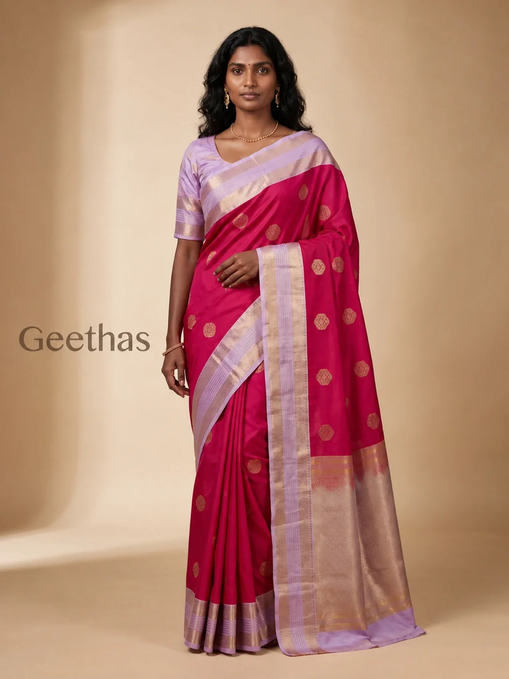 Model wearing a magenta soft silk saree with gold-toned woven motifs and a lavender zari border